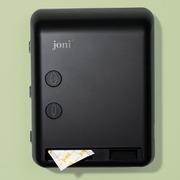 joni Model V smart period care dispenser on a green background