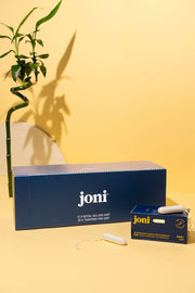 joni casepack of super tampons for commercial washrooms on a yellow background with bamboo