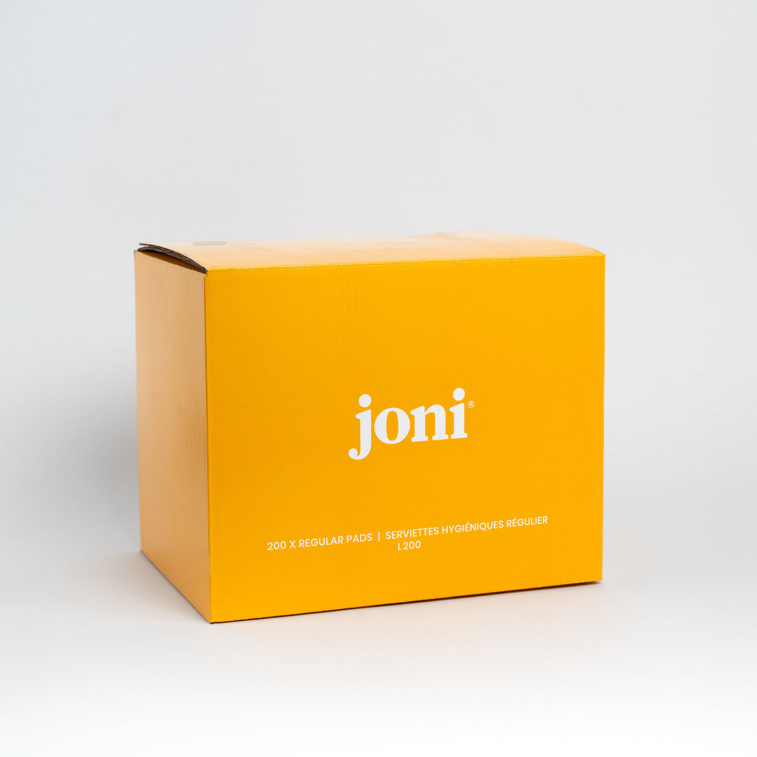 A bright yellow rectangular commercial product box of regular pads with the brand name 'joni' printed in white on the front, photographed on a clean light gray studio background.